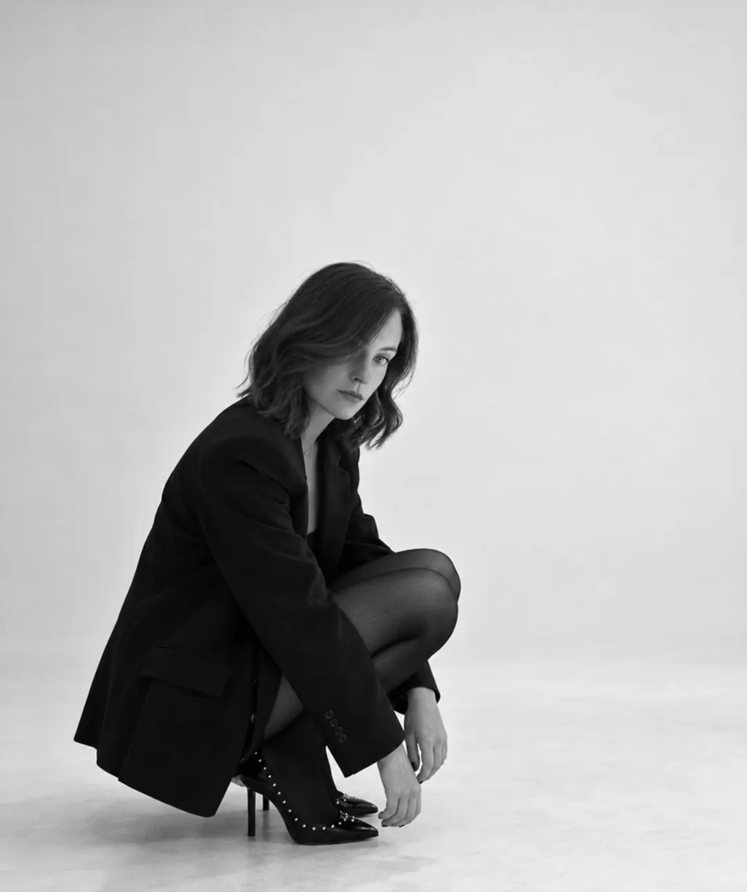 Chloé Boulet en portrait noir et blanc, accroupie en studio
